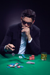 Games Addiction Ideas. Emotional Handsome Caucasian Brunet  Pocker Player At Pocker Table With Chips and Cards Playing and Drinking Alcohol