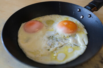 fried eggs close-up in a frying pan, homemade breakfast