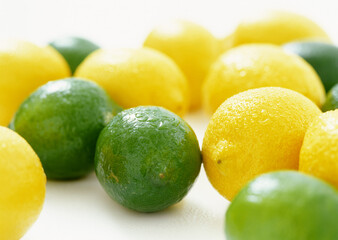 Multiple limes and lemons on white background