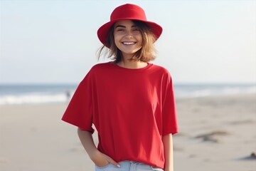 A woman in red tshirt and jeans smiles on beach - 770493196
