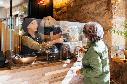 Woman Serving Cookies at Take Away Food Shop Counter