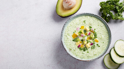 Green cucumber gazpacho cold cream soup styled and decorated in rustic bowl