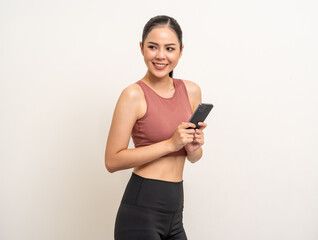 Naklejka premium Young beautiful asian woman with sportswear using smartphone on isolated white background. Attractive Portrait latin sporty woman standing pose holding cell phone exercise workout in studio.