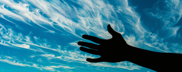Silhouette of a hand against a cloudy sky