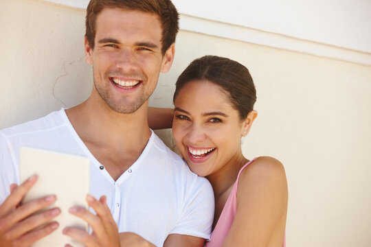 Couple, portrait and hug with tablet outdoor for photography, summer memories and happiness by wall. Man, woman and smile with technology for social media post, profile picture and travel influencers