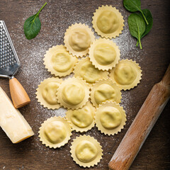 italian Ravioli with cheese and spinach on a wooden background, top view