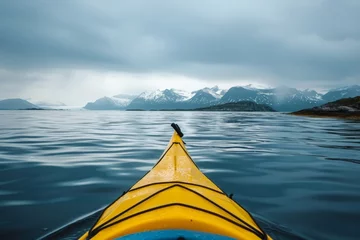 Küchenrückwand glas motiv A yellow kayak glides through the tranquil arctic sea, with majestic snow-capped mountains as a backdrop. © Philipp