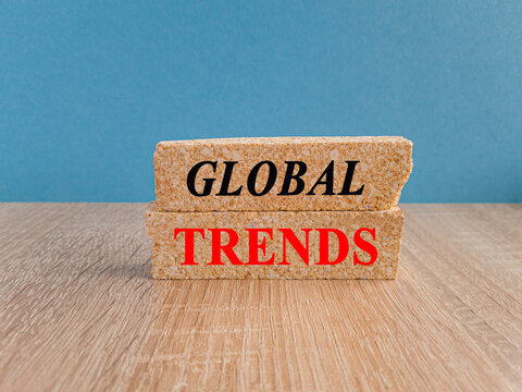 Trends symbol. Brick blocks with red words GLOBAL TRENDS. Beautiful blue background, wooden table. Copy space. Business concept.