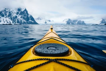 Rolgordijnen A yellow kayak glides through the tranquil arctic sea, with majestic snow-capped mountains as a backdrop. © Philipp