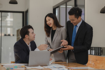 A group of employees happily work together in the office while discussing work that was completed on time as ordered by their boss, A group of entrepreneurs had fun working together.