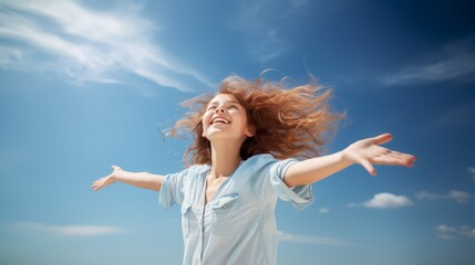 Happy girl with raising arms over blue sky at summer