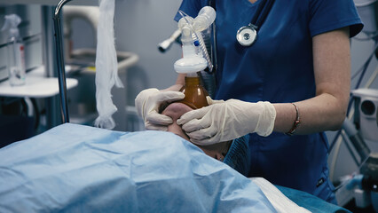A medical anastasiologist prepares a patient for surgery in a modern operating room. Medical...