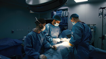 Close-up of mixed race surgeons in uniform working on an operation in a modern operating room....