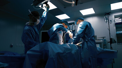 A team of professional surgeons perform an operation in a modern hospital. Medical staff, surgical...