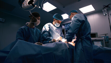 Close-up of surgeons in protective clothing in a modern operating room. Healthcare, surgery and...