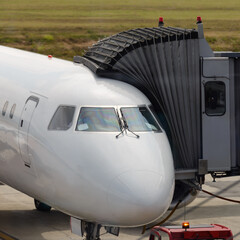 view of a mobile ramp for boarding passengers on an airplane attached to an airplane close-up