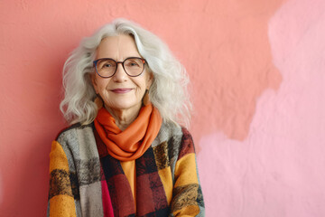 Portrait of an elderly woman wearing glasses against a bright wall on a sunny day.