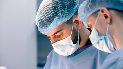 Close-up of surgeons in protective clothing in a modern operating room. Healthcare, surgery and...