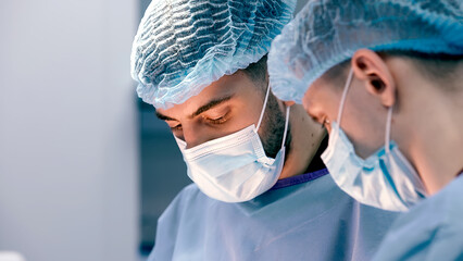 A team of professional surgeons perform an operation in a modern hospital. Medical staff, surgical...