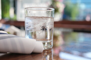 Glass with ice cubes on a wooden table in a restaurant. High quality photo