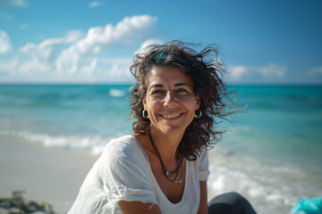 Happy mix raced woman about her 50 years, with curly hair smiling on the beach, capturing the...