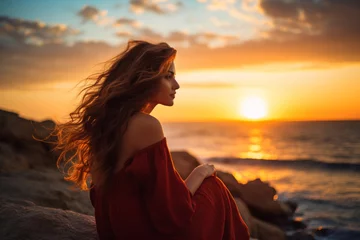 Fototapeten Young longhaired woman gazes at sunset over the sea, attractive, sensual pose, side view, warm golden hour colors © Studium L&M