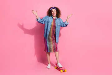 Full length photo of impressed funky lady dressed jeans outfit riding skateboard empty space isolated pink color background