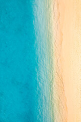 Relaxing aerial beach scene, summer vacation holiday landscape. Waves splash surf with amazing blue ocean lagoon sea sandy shore coastline. Perfect aerial drone top view. Peaceful bright beach seaside