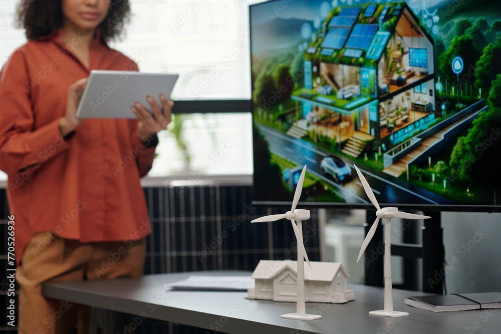 Aufkleber white plastic windmills standing on desk against house model and screen with visual template of new 