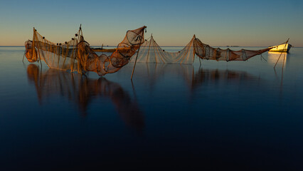 Fishing net on the calm waters of a sunrise in the Ebro delta, Catalonia, Spain.