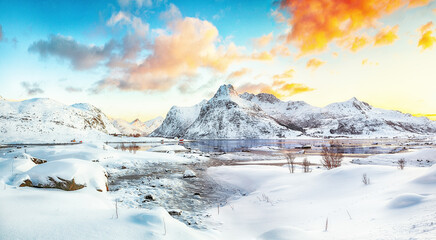 Picturesque frozen Flakstadpollen and Boosen fjords with cracks on ice during sunrise with Hustinden mountain on background on Flakstadoya island - obrazy, fototapety, plakaty
