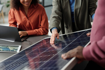 Cropped shot of young businesswoman in formalwear pointing at solar panel model while making...