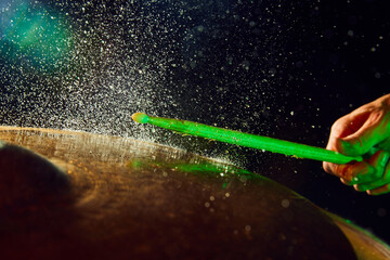 Close-up image of drum element on black background with light and waterdrops. Dynamics, energy....