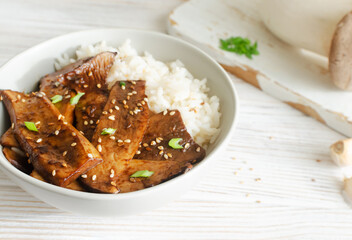 Eryngii mushroom fried with sesame and green onion and white boiled rice in a gray bowl. Dishes Gochujang King Oyster Mushrooms. Traditional Korean cuisine. Horizontal orientation. - obrazy, fototapety, plakaty