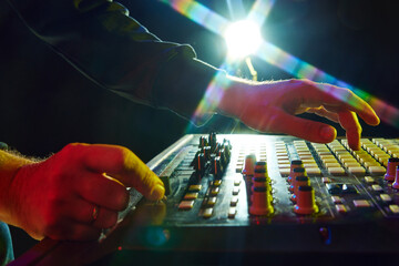 Electronic music, party and night club entertainment. Close-up of dj mixer, man adjusting sounds...
