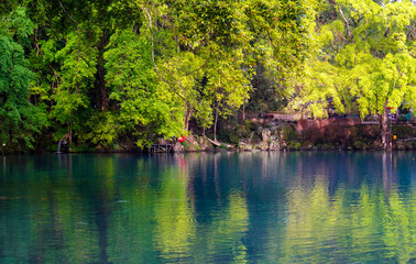 Fototapeta na wymiar Beautiful view of the blue lake surrounded by trees around it.