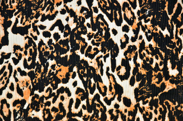 Leopard print (background) on a textured fabric, closeup