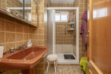 Vintage bathroom with brown fixtures and porcelain tiles and white shower cubicle with sliding...