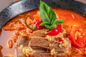 vegetable soup with bulgur, tomatoes and ribs. Food recipe background. Close up