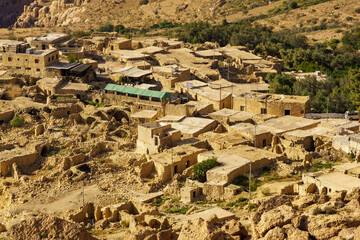 Picturesque traditional Ottoman village in Dana Biosphere Reserve in Jordan. Dilapidated very old walls of houses and fences along narrow streets. - obrazy, fototapety, plakaty