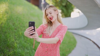 Young Woman in Red Dress Using Smartphone Outdoors