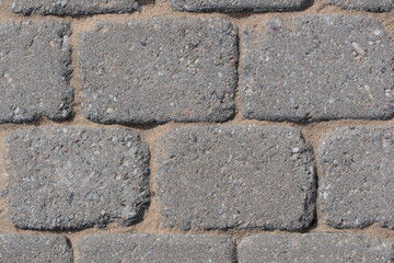 Restored gaps of paving slabs with sand after cleaning from moss and grass