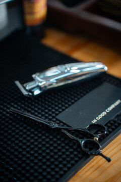 Scissor and clipper in barbeshop on dark rubber background