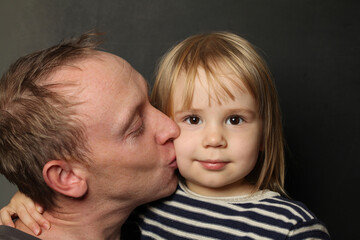 Family, fatherhood and people concept. Happy affectionate father kissing little baby daughter