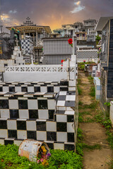 Famous cemetery, many mausoleums or large crypts decorated with tiles, often in black and white. Densely built buildings under a sunset Cimetière de Morne-à-l'eau, Grand Terre, Guadeloupe, Caribbean