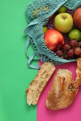 String bag with fresh fruits and pieces of bread on color background, flat lay
