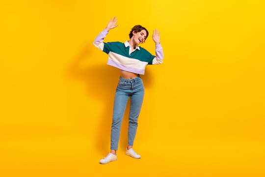 Full length photo of dreamy carefree lady dressed polo shirt dancing having fun isolated yellow color background