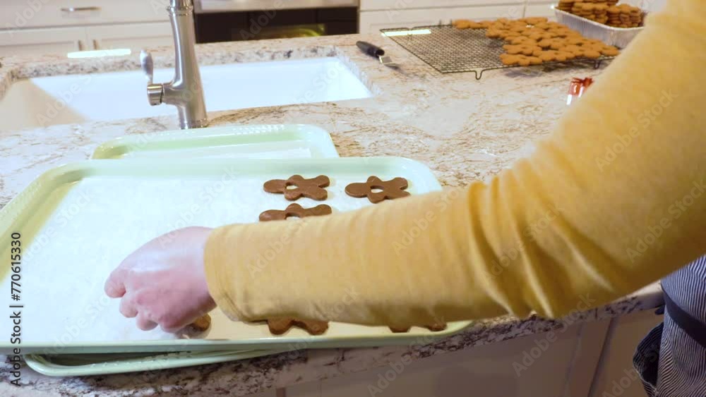 Sticker baking christmas gingerbread cookies in modern white kitchen