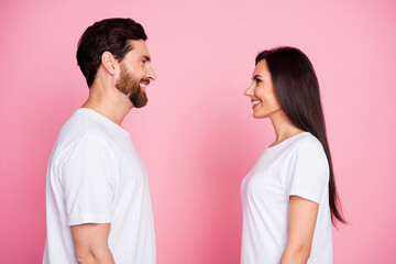 Photo portrait of nice young couple look each other smile wear trendy white outfit isolated on pink color background