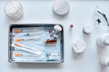 Minimal top view of medical dish with vaccines and syringes in clinic copy space